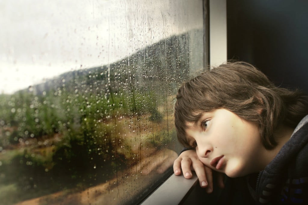 young boy looking out window