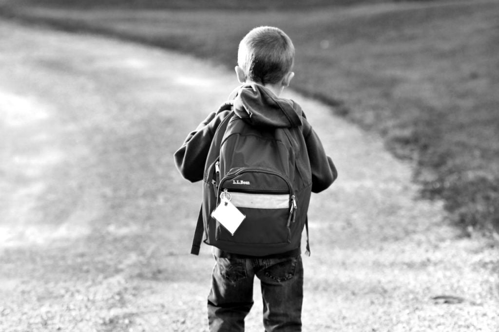 boy with backpack walking alone