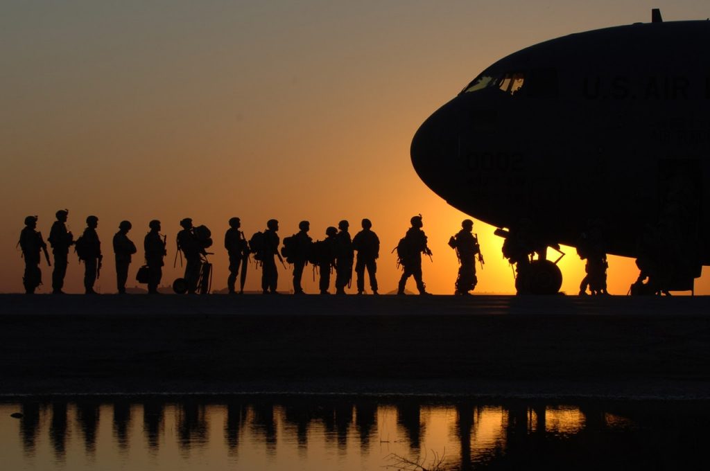 australian soldiers getting onto a plane at sunset