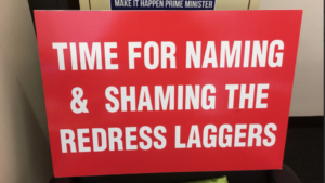 national redress scheme sign that says 'time for naming & shaming the redress laggers'