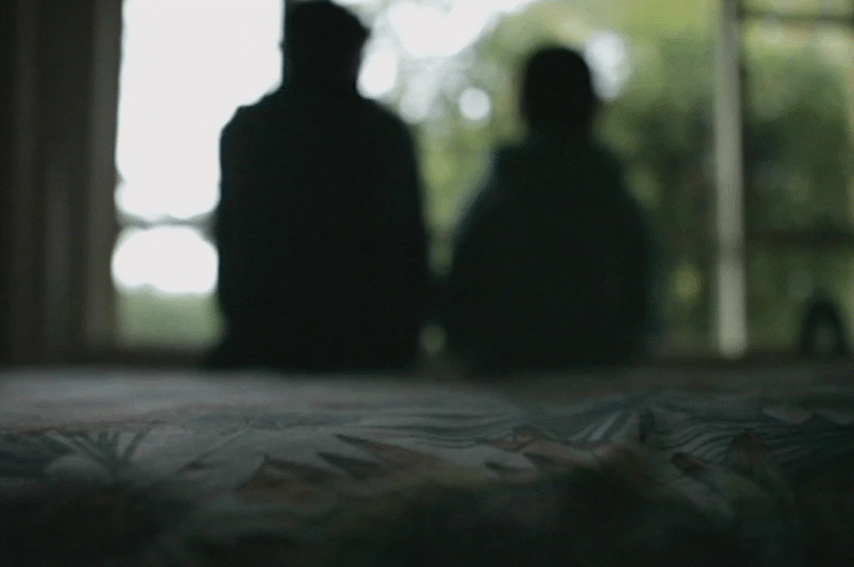 child and adult sitting on a bed
