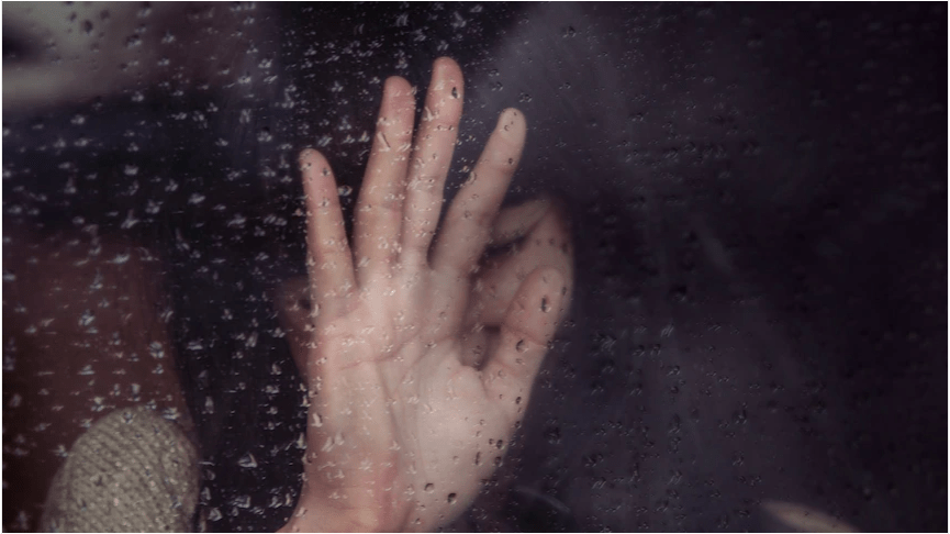 girl crying behind window