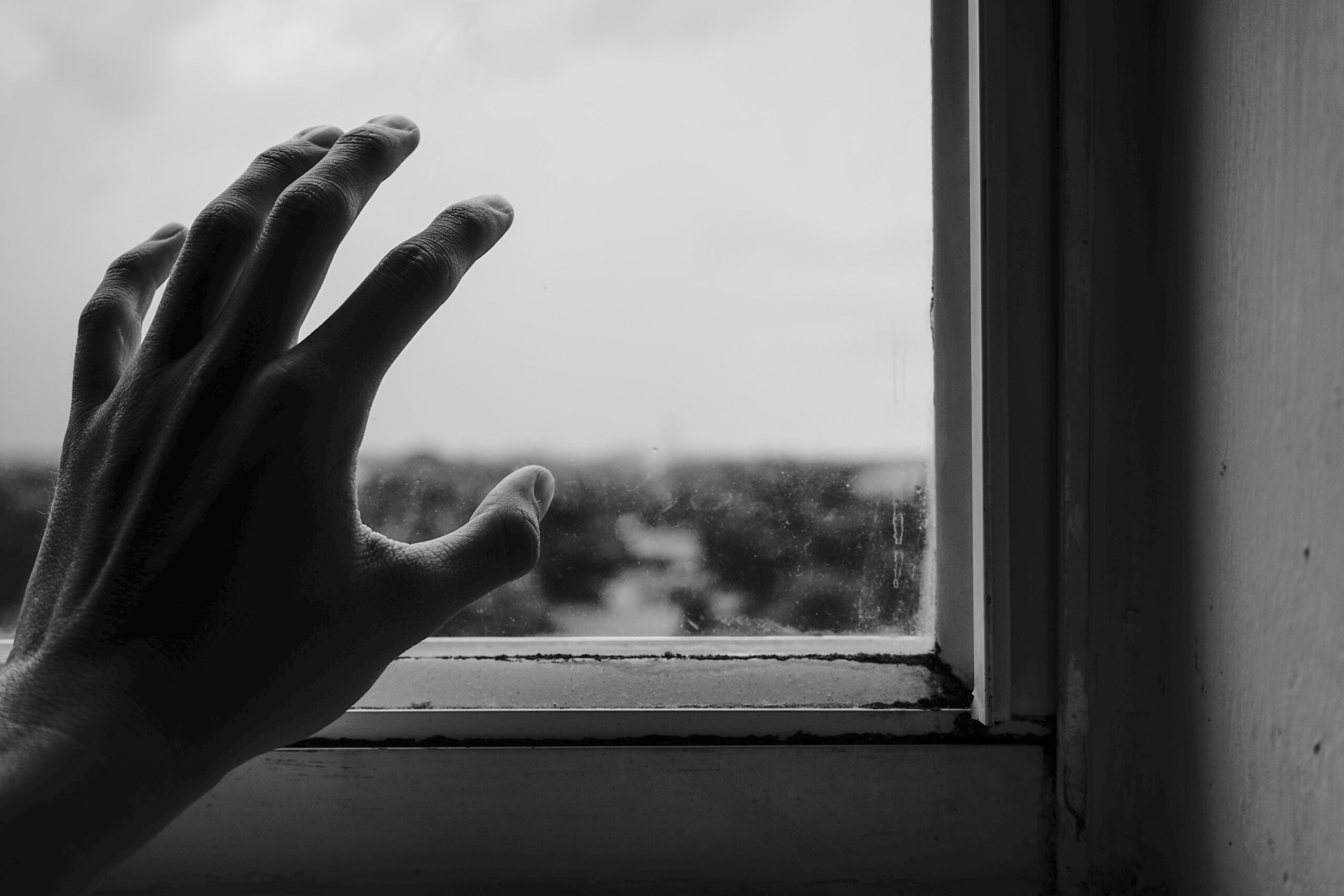 boy reaching towards a window